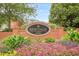 Community entrance sign with manicured landscaping and colorful flowers welcoming you to Heritage at Roswell at 3502 Village Green Dr, Roswell, GA 30075