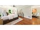 A primary bedroom featuring hardwood floors, a ceiling fan, tray ceilings, and a view into dining room at 522 Stell Rd, Woodstock, GA 30188