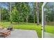 View of a backyard patio with a fire pit and seating, surrounded by a lush green lawn and trees at 2362 Browns Mill Rd, Atlanta, GA 30315