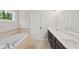 Bright bathroom with a long double vanity, soaking tub, and ample natural light at 2362 Browns Mill Rd, Atlanta, GA 30315