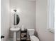 Bright powder room features a pedestal sink, oval mirror, and window with blinds at 2362 Browns Mill Rd, Atlanta, GA 30315