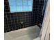 Bathroom with black tiled walls and a frosted block window allowing natural light at 284 Lakeview Ne Ave, Atlanta, GA 30305