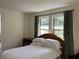 Bedroom featuring two windows, a woven headboard, and simple decor; bathed in natural light at 284 Lakeview Ne Ave, Atlanta, GA 30305