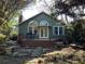 Landscaped backyard featuring a charming green house with a wooden deck and outdoor seating area at 284 Lakeview Ne Ave, Atlanta, GA 30305