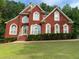 Charming two-story brick home with a well-manicured lawn and lush landscaping at 3008 Sunrise Ct, Conyers, GA 30094