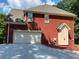 Brick home featuring a wide garage door, and a manicured landscape at 3008 Sunrise Ct, Conyers, GA 30094