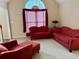 Cozy living room with comfortable red sofas and a large window at 3008 Sunrise Ct, Conyers, GA 30094