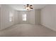 Spacious bedroom featuring neutral carpeting, a ceiling fan, and ample natural light from the windows at 340 Antebellum Way, Fayetteville, GA 30215