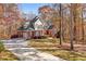 Attractive brick home with an attached garage and long driveway surrounded by colorful trees at 340 Antebellum Way, Fayetteville, GA 30215