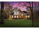 Charming two-story brick home with lush lawn, mature trees and colorful sunset sky at 340 Antebellum Way, Fayetteville, GA 30215