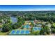 Enjoy this aerial view of tennis courts, a playground, a lake, and lush green trees surrounding the neighborhood at 3905 Greenside Ct, Dacula, GA 30019