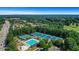 Overhead view of the neighborhood pool, tennis courts, playground, and parking area with lush trees all around at 3905 Greenside Ct, Dacula, GA 30019