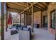 A covered porch with dark wicker seating and a brick exterior at 3905 Greenside Ct, Dacula, GA 30019