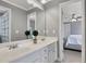 Bathroom with double sinks, a large mirror, and a view into an adjacent bedroom, providing a bright and open feel at 3905 Greenside Ct, Dacula, GA 30019