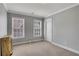 Bright bedroom with neutral walls, two windows, a white door, and minimal decor, creating a serene and inviting space at 3905 Greenside Ct, Dacula, GA 30019