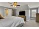 Comfortable bedroom with a large bed, side table, and television, offering a relaxing space with natural light at 3905 Greenside Ct, Dacula, GA 30019