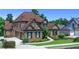 Beautiful two-story brick home featuring a manicured lawn, mature trees, and attached two-car garage at 3905 Greenside Ct, Dacula, GA 30019