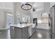 Bright kitchen featuring high ceilings, an island with sink, modern countertops, and stainless-steel appliances at 3905 Greenside Ct, Dacula, GA 30019