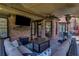 Outdoor living space with a brick fireplace, a TV, and comfortable seating at 3905 Greenside Ct, Dacula, GA 30019