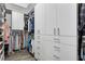 Organized walk-in closet with custom shelving, ample hanging space, and white drawers at 3905 Greenside Ct, Dacula, GA 30019
