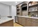 An elegant wet bar with granite countertops, stainless steel mini-fridge and custom cabinetry at 3905 Greenside Ct, Dacula, GA 30019