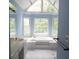 Bright bathroom featuring a soaking tub, bay window, and vanity with ample natural light at 1205 Pebble Bend Dr, Grayson, GA 30017