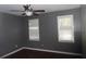 Cozy bedroom with dark hardwood floors, ceiling fan, and two windows with blinds at 1205 Pebble Bend Dr, Grayson, GA 30017