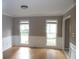 Bright living room featuring hardwood floors, crown molding, and natural light from two windows at 1205 Pebble Bend Dr, Grayson, GA 30017