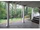 Covered patio with white pillars overlooking grassy yard and a wooded area at 1205 Pebble Bend Dr, Grayson, GA 30017