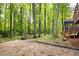 Backyard view featuring mature trees, a swing set, play area, and wooden staircase to an upper deck at 3292 Holly Mill Ct, Marietta, GA 30062