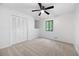 A carpeted bedroom featuring a ceiling fan, closet, and window overlooking the wooded view at 3292 Holly Mill Ct, Marietta, GA 30062