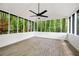 Relaxing sunroom with wood-look flooring and screened windows offering serene wooded views and a ceiling fan at 3292 Holly Mill Ct, Marietta, GA 30062