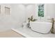 Bright bathroom featuring a modern tub, stylish fixtures, and a serene window view at 4642 Orchid Dr, Pine Lake, GA 30072