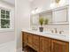 Bathroom featuring a double sink vanity with wood cabinets, granite counters, and modern fixtures at 4642 Orchid Dr, Pine Lake, GA 30072
