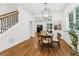 Dining room showcasing hardwood floors, modern chandelier, and an adjacent staircase leading to the upper level at 4642 Orchid Dr, Pine Lake, GA 30072