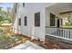 Side view of charming home featuring modern windows and stone accents on the porch at 4642 Orchid Dr, Pine Lake, GA 30072