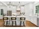 Bright, modern kitchen with white cabinetry, marble island with bar seating, and pendant lighting at 4642 Orchid Dr, Pine Lake, GA 30072