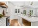 Modern kitchen with white cabinets, a marble island, a stainless steel range, and outside access at 4642 Orchid Dr, Pine Lake, GA 30072
