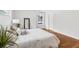 Bright main bedroom features hardwood floors, a mirror, and soft, inviting bedding for a tranquil space at 4642 Orchid Dr, Pine Lake, GA 30072