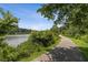 Picturesque view of a paved path winding along a lake with trees at 4642 Orchid Dr, Pine Lake, GA 30072