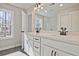 Bright bathroom featuring double sinks with modern fixtures and a large mirror reflecting natural light from the window at 687 Sunstone Ln, Lawrenceville, GA 30043