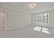 A spacious bedroom with plush carpeting, neutral walls, and a large window providing plenty of natural light at 687 Sunstone Ln, Lawrenceville, GA 30043