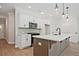 Well-lit kitchen with stainless steel appliances, white cabinetry, and quartz countertops at 687 Sunstone Ln, Lawrenceville, GA 30043