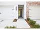 Close up of the front entry with white garage doors and professionally landscaped grounds at 695 Sunstone Ln, Lawrenceville, GA 30043