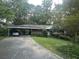 Cozy single-story home with a covered carport and a front yard surrounded by mature trees and greenery at 1164 Rogeretta Ne Dr, Atlanta, GA 30329