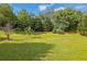 Beautiful backyard with a big green lawn and mature trees, offering ample space at 425 Eldridge Drive Dr, Suwanee, GA 30024