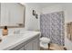 This bathroom has a gray vanity, framed mirror, and a shower with a decorative curtain at 425 Eldridge Drive Dr, Suwanee, GA 30024