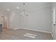 Bright dining room features modern chandelier and neutral color palette with light, luxury vinyl plank flooring at 689 Sunstone Ln, Lawrenceville, GA 30043