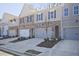 Townhome row showcases brick and vinyl exteriors, with driveways leading to garages and coordinated landscaping at 689 Sunstone Ln, Lawrenceville, GA 30043