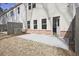 View of the backyard with a concrete patio and access to the home, featuring brick foundation and neutral siding at 693 Sunstone Ln, Lawrenceville, GA 30043